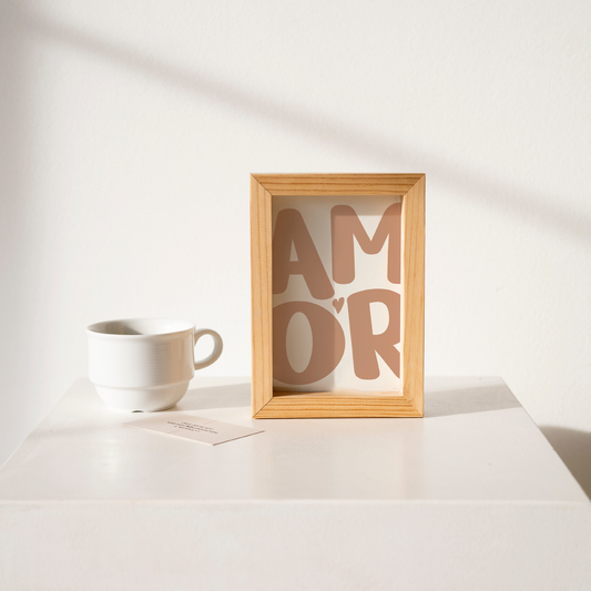 Small 'AMOR' Modern Aesthetic Wall Art Print in pinky nude on white. Framed cute wall decor on a clean white table.