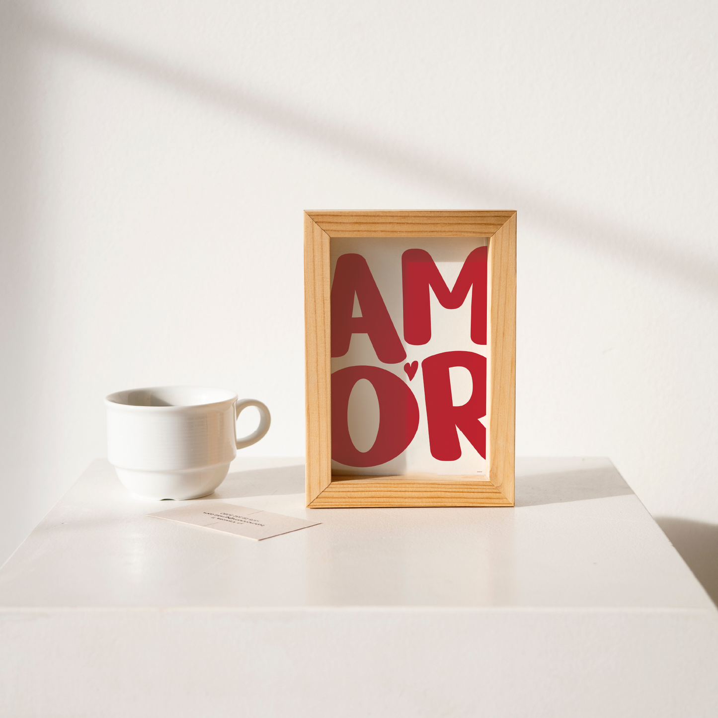 Small 'AMOR' Modern Aesthetic Wall Art Print in red on white. Framed cute wall decor on a clean white table.
