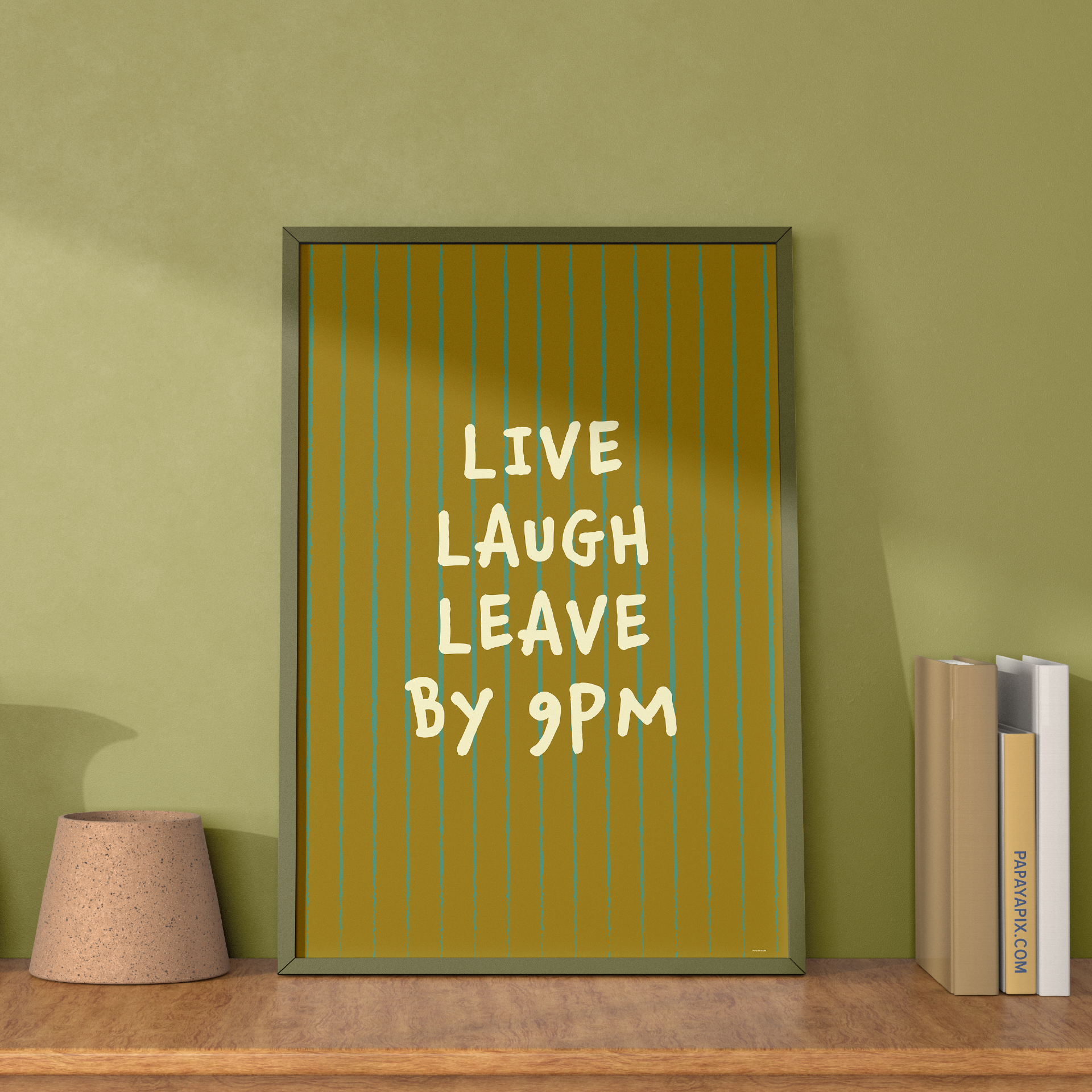 Large "Live, Laugh, Leave by 9 PM" Wall Art Print in green. Framed cute wall decor / entryway artwork next to some books, leaning against light green wall.