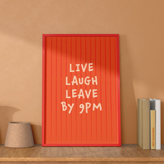 Large "Live, Laugh, Leave by 9 PM" Wall Art Print in coral. Framed cute wall decor / entryway artwork next to some books, leaning against a soft orange wall.